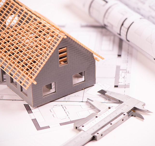 Maqueta de una casa sobre unos planos de arquitectura